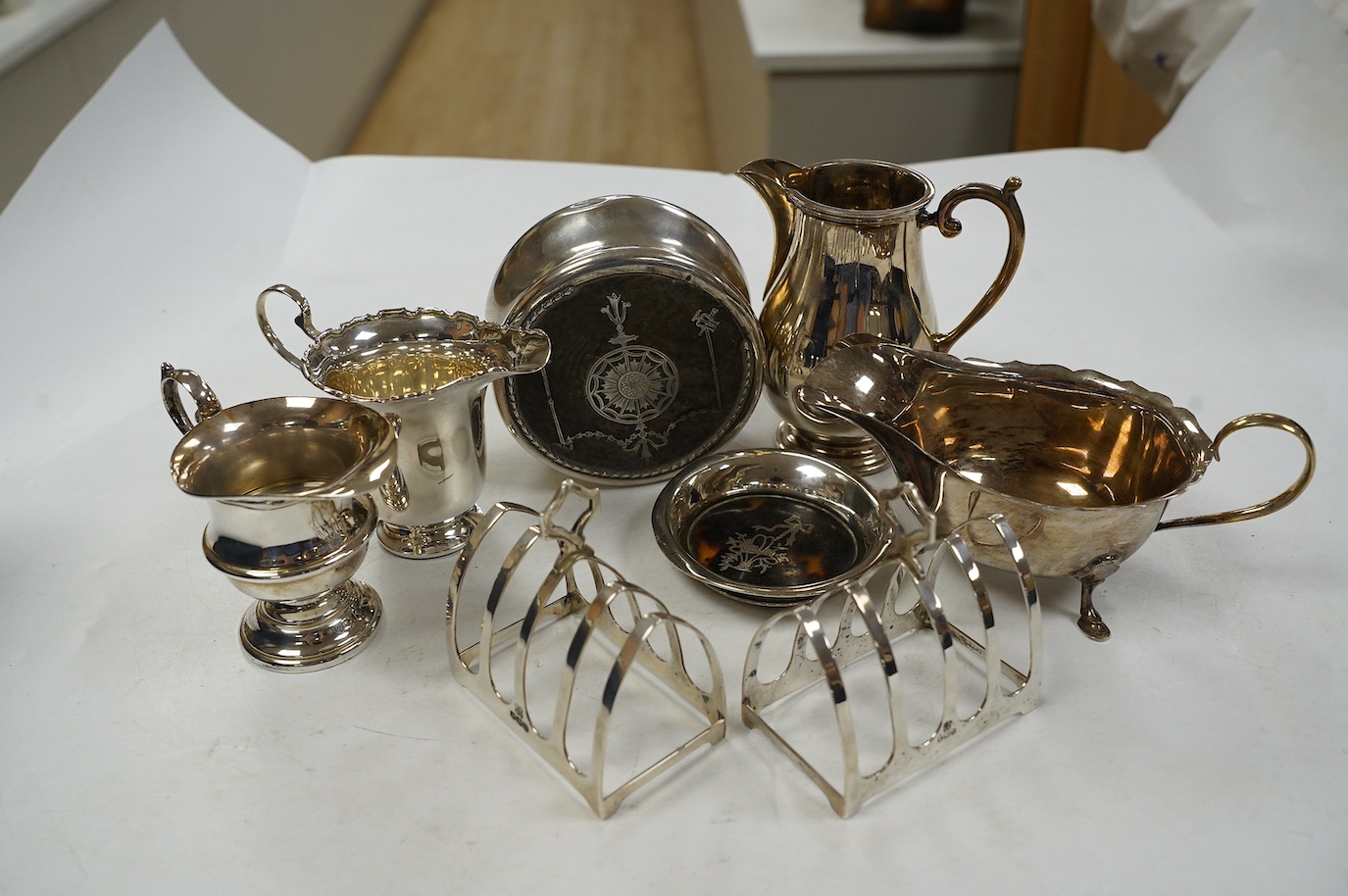 Sundry small silver including a pair of toast racks, Sheffield, 1936, three cream jugs, a sauceboat and two tortoiseshell mounted items. Condition - poor to fair to good